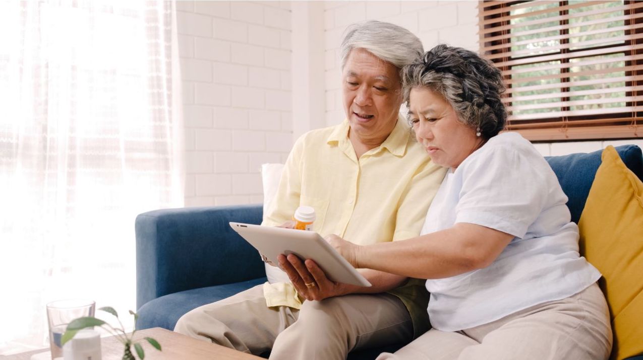 Senior couple watching a movie on a tablet
