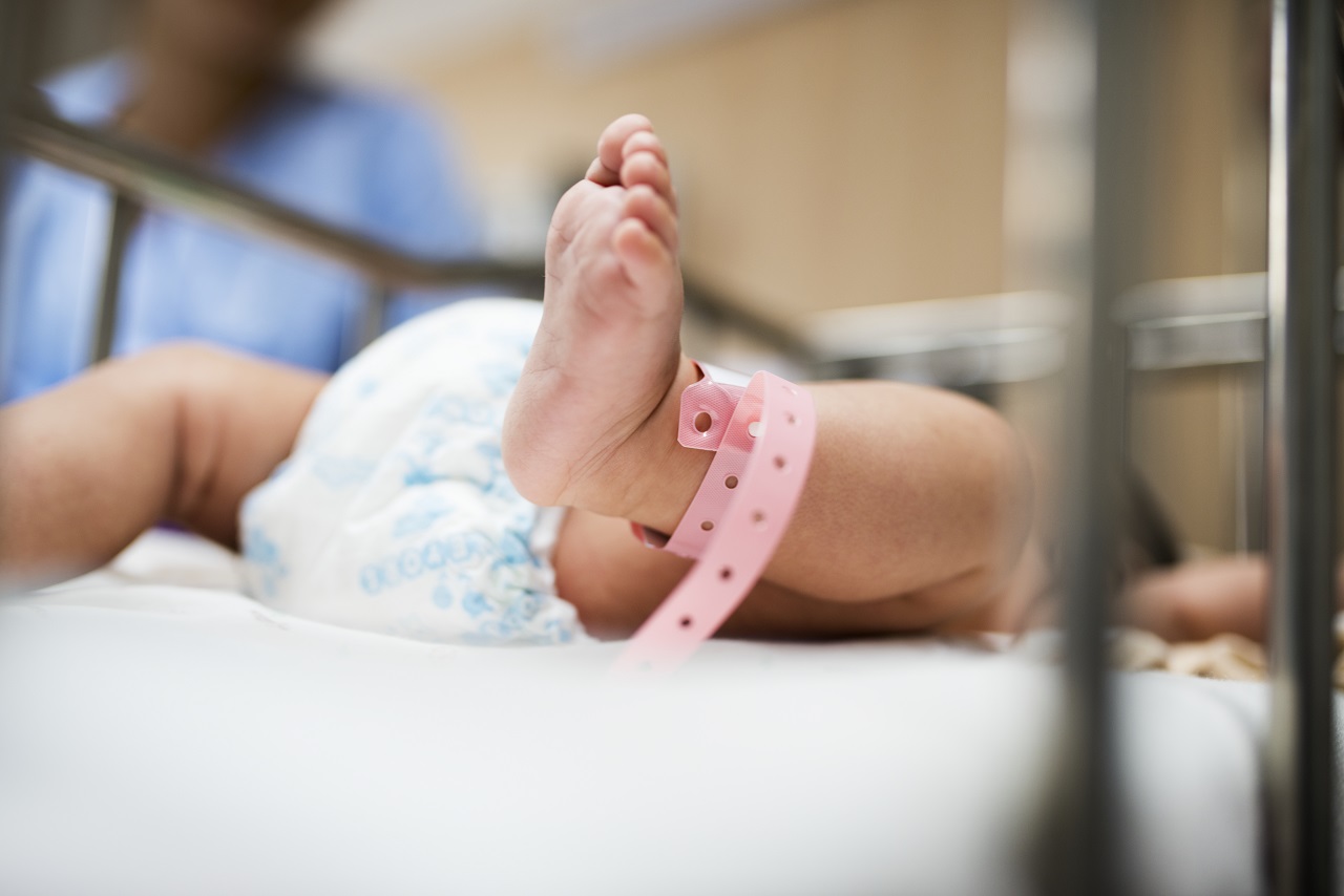 Close up of a newborn baby laid down in a hospital bed