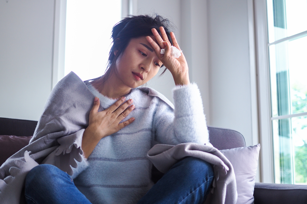 A woman feeling COVID-19 symptoms at home