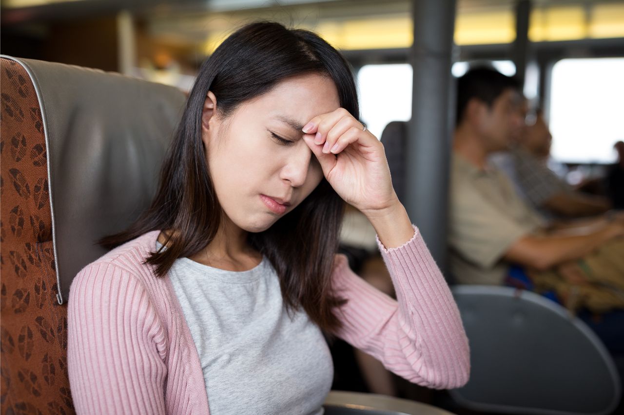 Woman experiencing a headache inside a bus